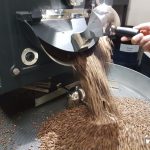 Kaffeebohnen werden in Röster geschüttet